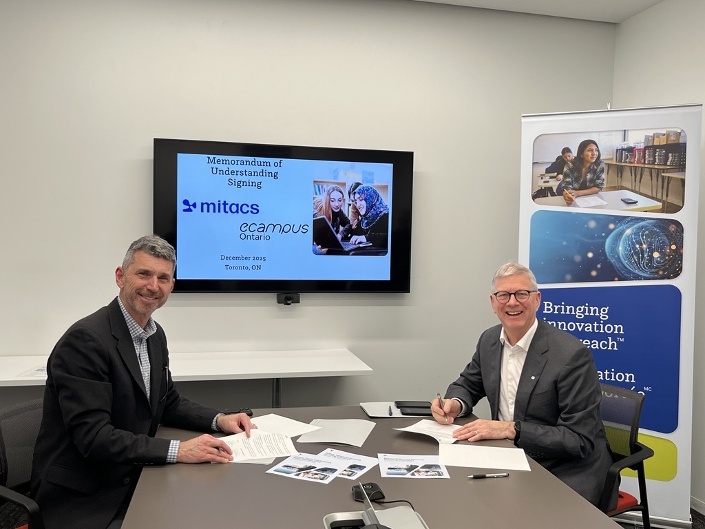 Two men in suits smile while signing documents at a table. Behind them, a screen displays “Memorandum of Understanding signing, Mitacs, eCampus Ontario,” highlighting the Mitacs Strategic Plan 2026-2030: Talent and Research Powering Innovation.